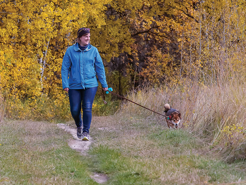 A woman walking a dog along the trails at the Brandon Hills Wildlife Management Area.