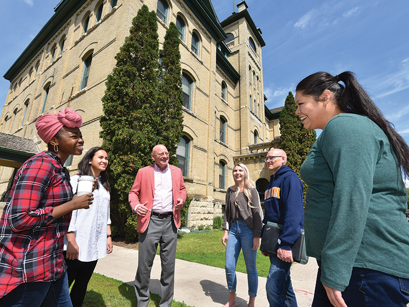 BU President David Docherty (centre) meets with students on the BU campus