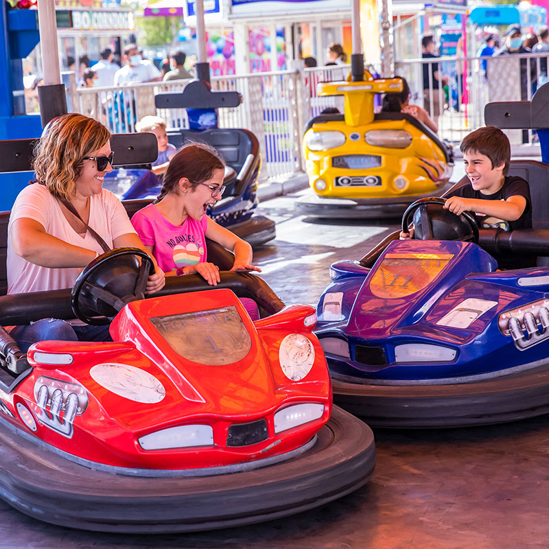 Mother and children in bumper cars at the Manitoba Summer Fair, Brandon, Manitoba